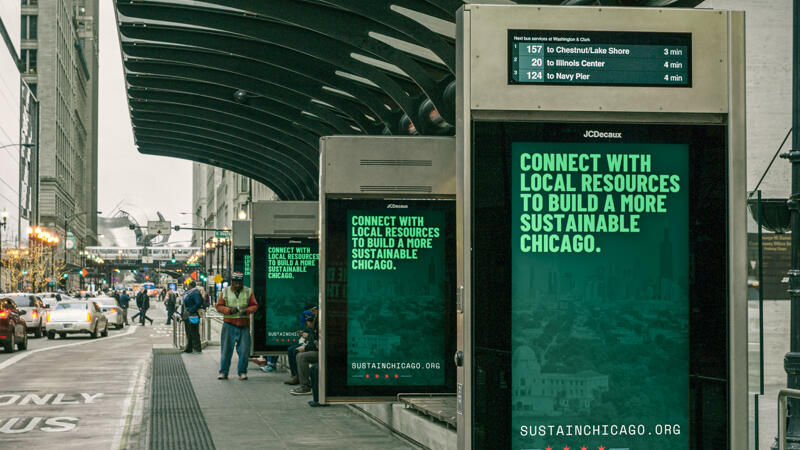 Series of four downtown bus stop signs that say connect with local resources to build a more sustainable chicago.