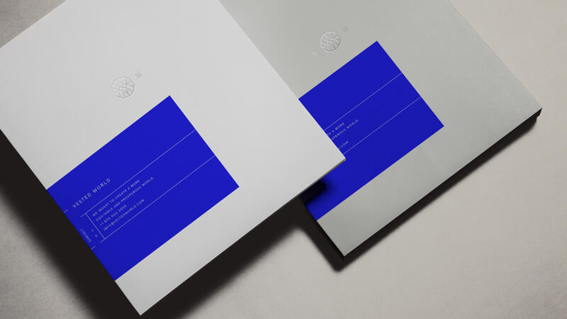 Vested World stationery and booklets featuring logo and brand colors